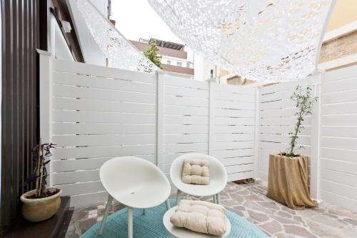 a room with two white chairs and a wall at Borgo Centrale Rooms in Pescara