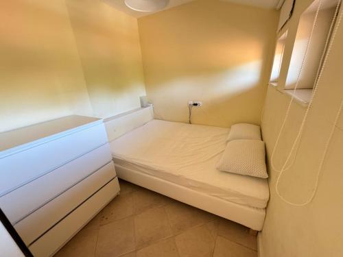 a small room with a bed and a cabinet at Santa Marina resort Sozopol - penthouse with amazing sea view in Sozopol