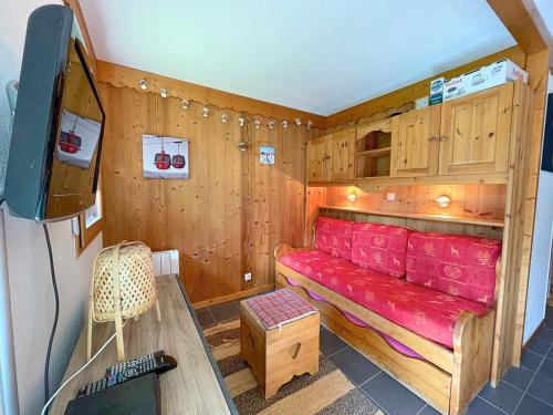 une petite pièce avec un canapé rouge et une télévision dans l'établissement Studio rénové style montagne pour 4 pers aux Menuires, balcon est, accès direct pistes - FR-1-452-22, aux Menuires