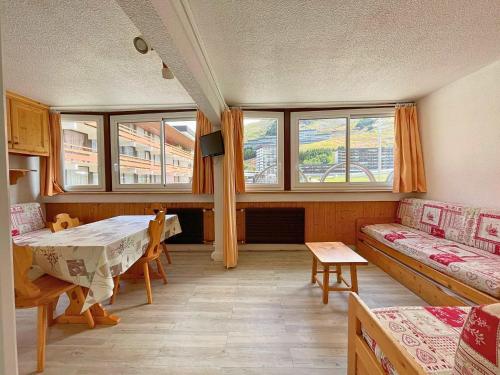 Cette chambre comprend une table, un canapé et des fenêtres. dans l'établissement Studio Les Menuires pour 4 pers avec animaux admis et casier à skis - FR-1-452-231, aux Menuires