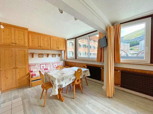 d'une salle à manger avec une table et quelques fenêtres. dans l'établissement Studio Les Menuires pour 4 pers avec animaux admis et casier à skis - FR-1-452-231, aux Menuires