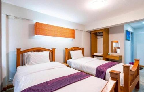 a bedroom with two beds and a window at XX GO INN Bangkok Khaosan Road - โก อินน์ ถนน ข้าวสาร กรุงเทพ Pro in Bangkok