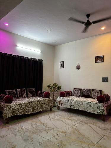 a living room with two beds and a ceiling fan at Sihi 3bhk Homestay in Jāmb