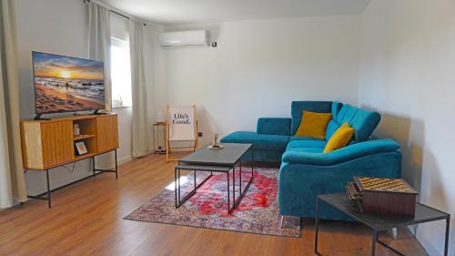 a living room with a blue couch and a tv at Biba’s Place in Blagaj