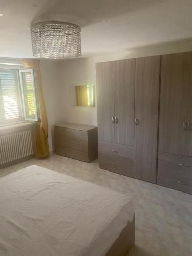 a large bedroom with wooden cabinets and a chandelier at Casa del mare in Cupra Marittima