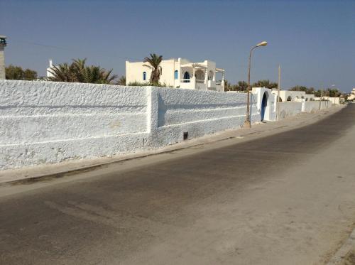 a white fence on the side of a road at La Brise de Djerba, Villa de Charme en bord de mer à Al Jazira in Mezraya