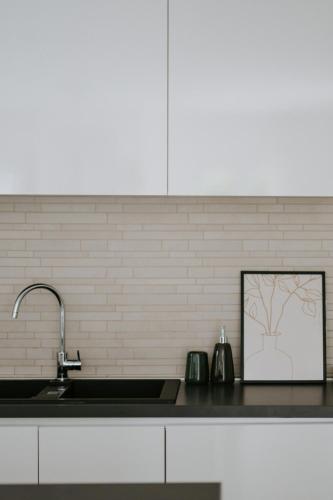 a kitchen counter with a sink and a picture at Villa Melograno by Domus Mirus - Rooftop Cinema, Pool, 6-Minute Walk to Beach in Splitska