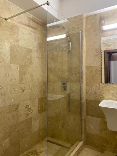 a bathroom with a glass shower and a sink at Hotel Victoria in Costinesti