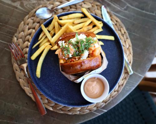 a blue plate with a hot dog and french fries at Villas Caracol in Holbox Island