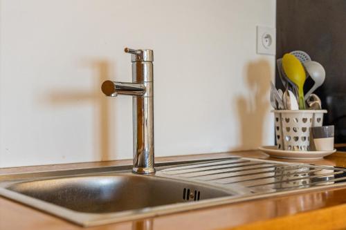 a stainless steel kitchen sink with a faucet at Studio Ô Calm - Confort & sérénité, proche aéroport in Saint-Denis