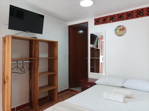 a bedroom with a bed and a tv on the wall at Petroglifo Room Támesis in Támesis