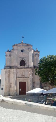 an old church with a cross on top of it at Casa MiKiaMi in Monte SantʼAngelo