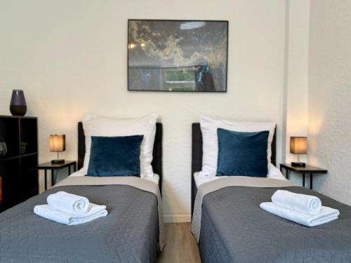 two beds sitting next to each other in a room at TT Living Apartments BONITAS & DIVINITAS I 2 Schlafzimmer I Küche I Vollbad I Waschmaschine in Rellingen