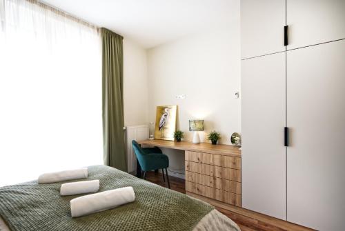 a bedroom with a bed and a desk and a window at Lonyay Downtown Apartment by FirstHost in Budapest