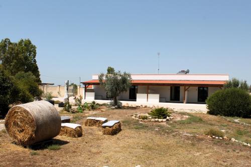 a building with a large bale of hay and benches at Tenuta Petra Chiara in Torre Lapillo