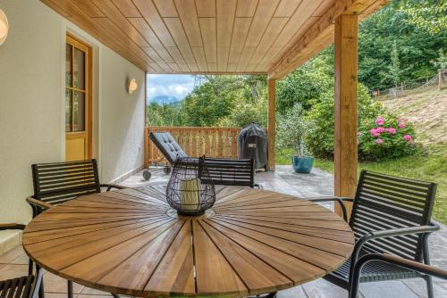 a wooden table and chairs on a patio at ELA Apartments Traunkirchen in Traunkirchen