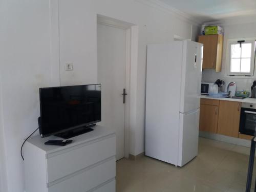 a kitchen with a white refrigerator and a tv on a dresser at Tuneras Sunset Puerto Rico Apartment in Mogán