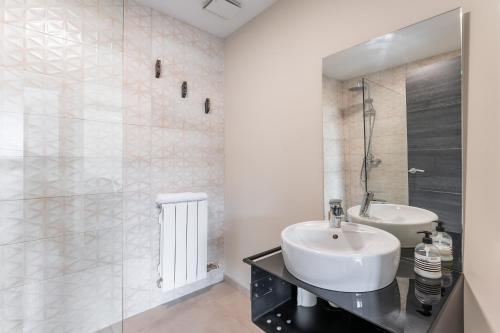 a white bathroom with a sink and a shower at Apartamentos Cubicos in Bronchales