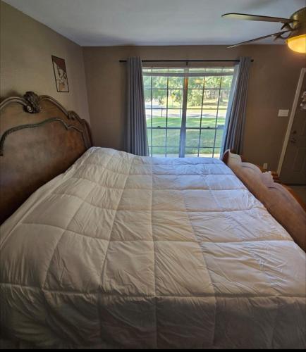 a bedroom with a large white bed with a window at 5 Fully Appointed Bedroom House in Baker