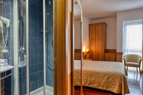 a bedroom with a bed and a shower at BV Grand Hotel Assisi in Assisi