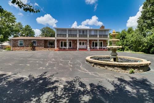 a house with a fountain in front of a building at Hidden Paradise on 5 Acres with Hot Tub and Deck! in Black Jack