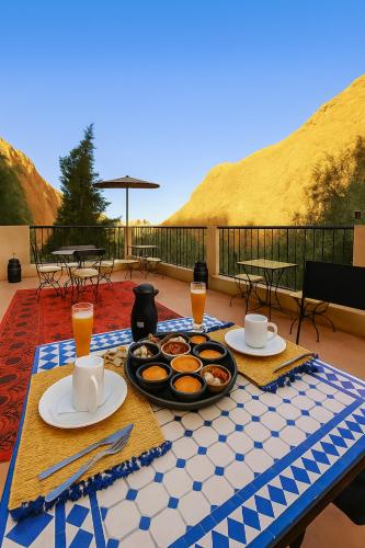 a table with plates of food on top of a patio at Auberge La Fibule Du Dades in Aït Idaïr