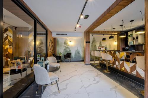 a lobby with white chairs and a dining area at TatryGold - Białka SPA & Resort - Apartament Potoku Szum in Białka Tatrzanska