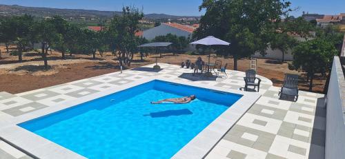 a man is laying in a swimming pool at Casa Cor do Vinho in Vila de Frades