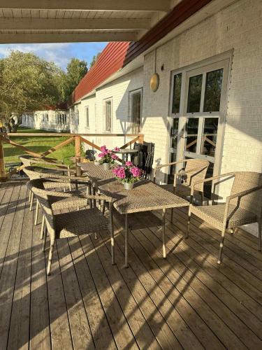 a wooden deck with tables and chairs on a house at Burning Bridge Motell & Vandrarhem in Götene