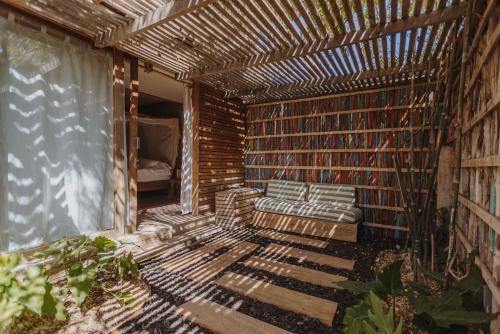 a room with a bench and a wall of books at Eco Lodge Mancora in Máncora