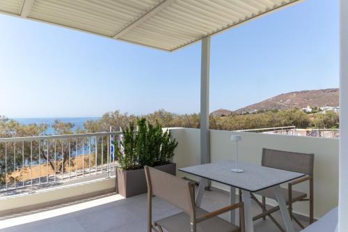 a patio with a table and chairs on a balcony at KYMA Suites Andros in Gavrion