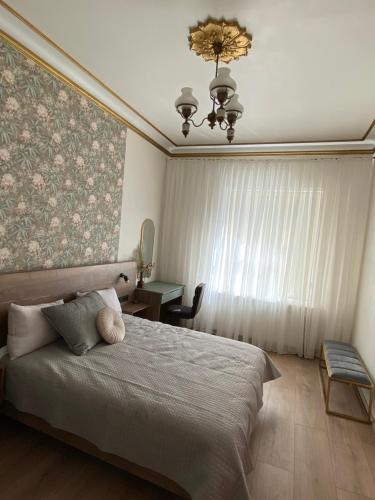 a bedroom with a large bed and a chandelier at Zviedru Nams in Liepāja