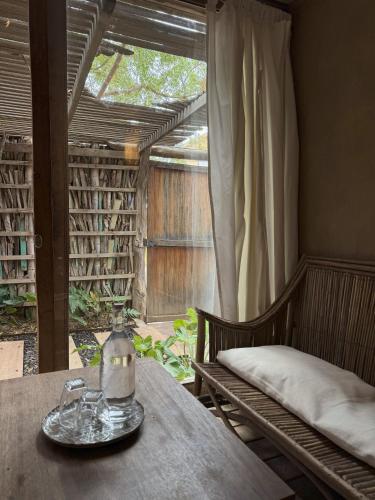 a table in a room with a window and a bench at Eco Lodge Mancora in Máncora