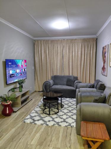a living room with a couch and a tv at Mont Pelaan 88 in Newcastle
