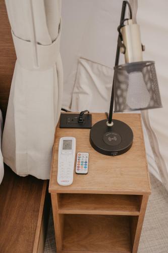 a bedside table with a lamp and a remote control at Campera Valle de Guadalupe in Ensenada