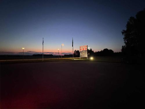 a street at night with a sign and street lights at Burning Bridge Motell & Vandrarhem in Götene