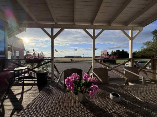 a patio with a table with flowers on it at Burning Bridge Motell & Vandrarhem in Götene