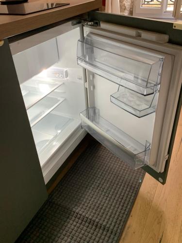 un réfrigérateur vide avec sa porte ouverte dans une cuisine dans l'établissement STUDIO PARIS ODEON, à Paris
