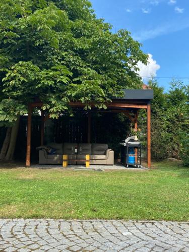 a pavilion with a couch under a tree at +Authentic+ in Mariánské Lázně