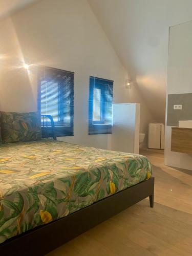 a bedroom with a bed and two windows at Hoeve DeKleinheide 1 in Dessel