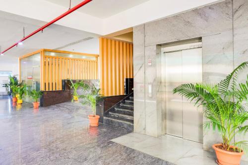 a lobby with potted plants in a building at Super Townhouse Visakhapatnam in Visakhapatnam