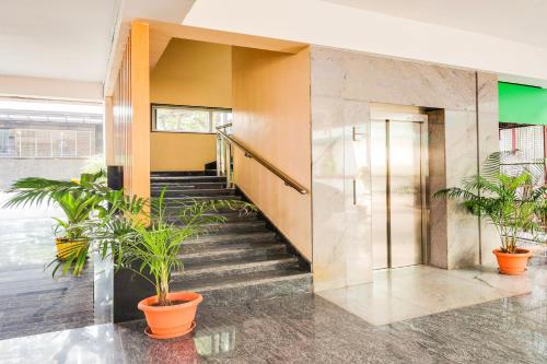 a staircase in a building with potted plants at Super Townhouse Visakhapatnam in Visakhapatnam
