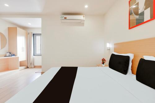 a bedroom with a large bed with black and white sheets at Super Townhouse Visakhapatnam in Visakhapatnam