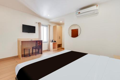 a hotel room with a bed and a tv at Super Townhouse Visakhapatnam in Visakhapatnam