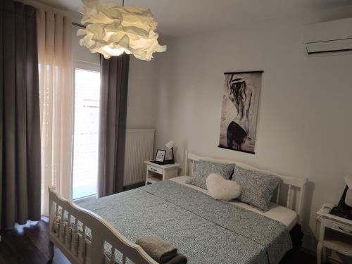 a bedroom with a bed and a chandelier at Black and White Apartment - 2 bedrooms, walk to the beach in Duće