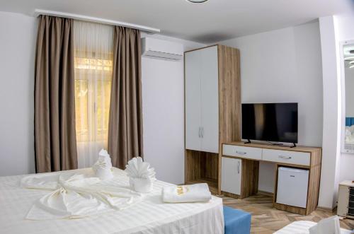 a hotel room with a bed and a television at Villa Osmani in Shkodër
