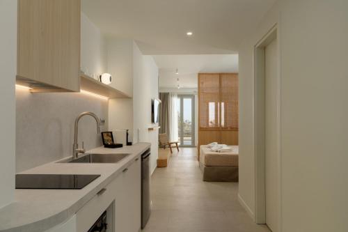 a kitchen with a sink and a living room at KYMA Suites Andros in Gavrion