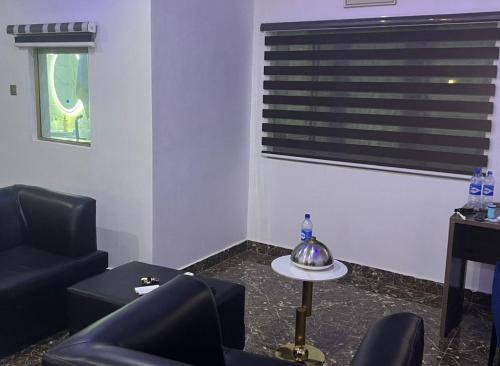 a living room with black furniture and a window at Basil Hotel and Suites in Otu
