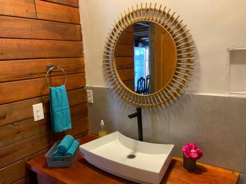 a bathroom with a white sink and a mirror at Peaceful Refuge in Quiete Bay in Bocas del Toro