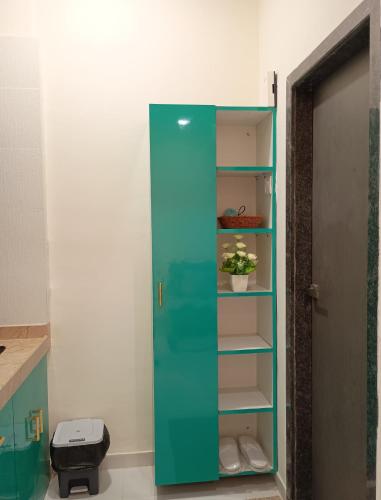 a green cabinet with a plant in it next to a door at Glorious Studio Hill view with pvt Balcony Karjat in Bhimashankar